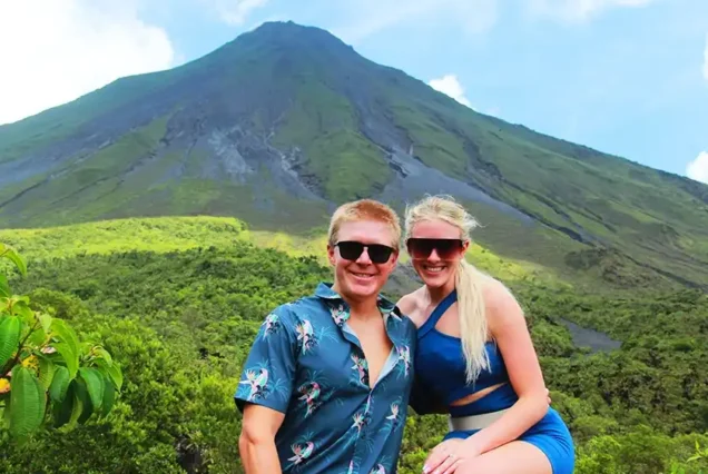 alt="Panoramic view of Arenal Volcano under clear blue sky"