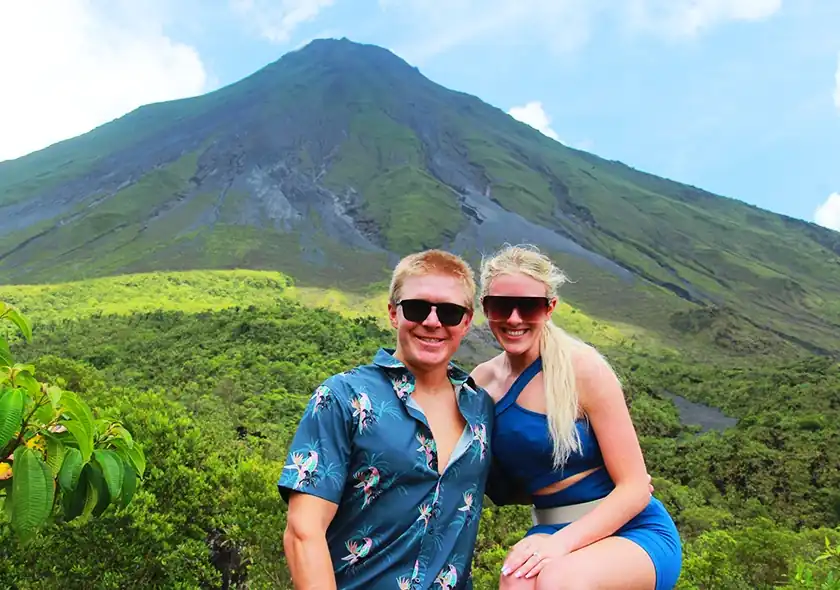 alt="Panoramic view of Arenal Volcano under clear blue sky"